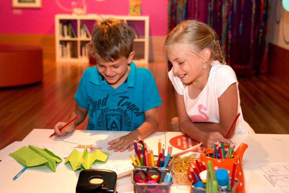 Two children drawing at a table