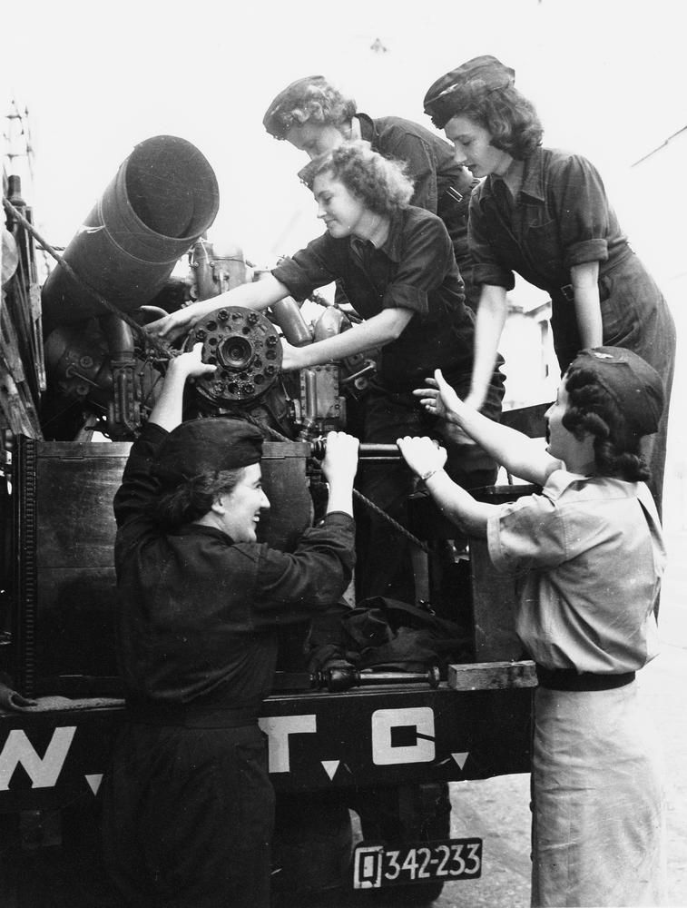5 members of the Women's Auxiliary Transport Corps around the back of a truck with salvage metal, 1942.