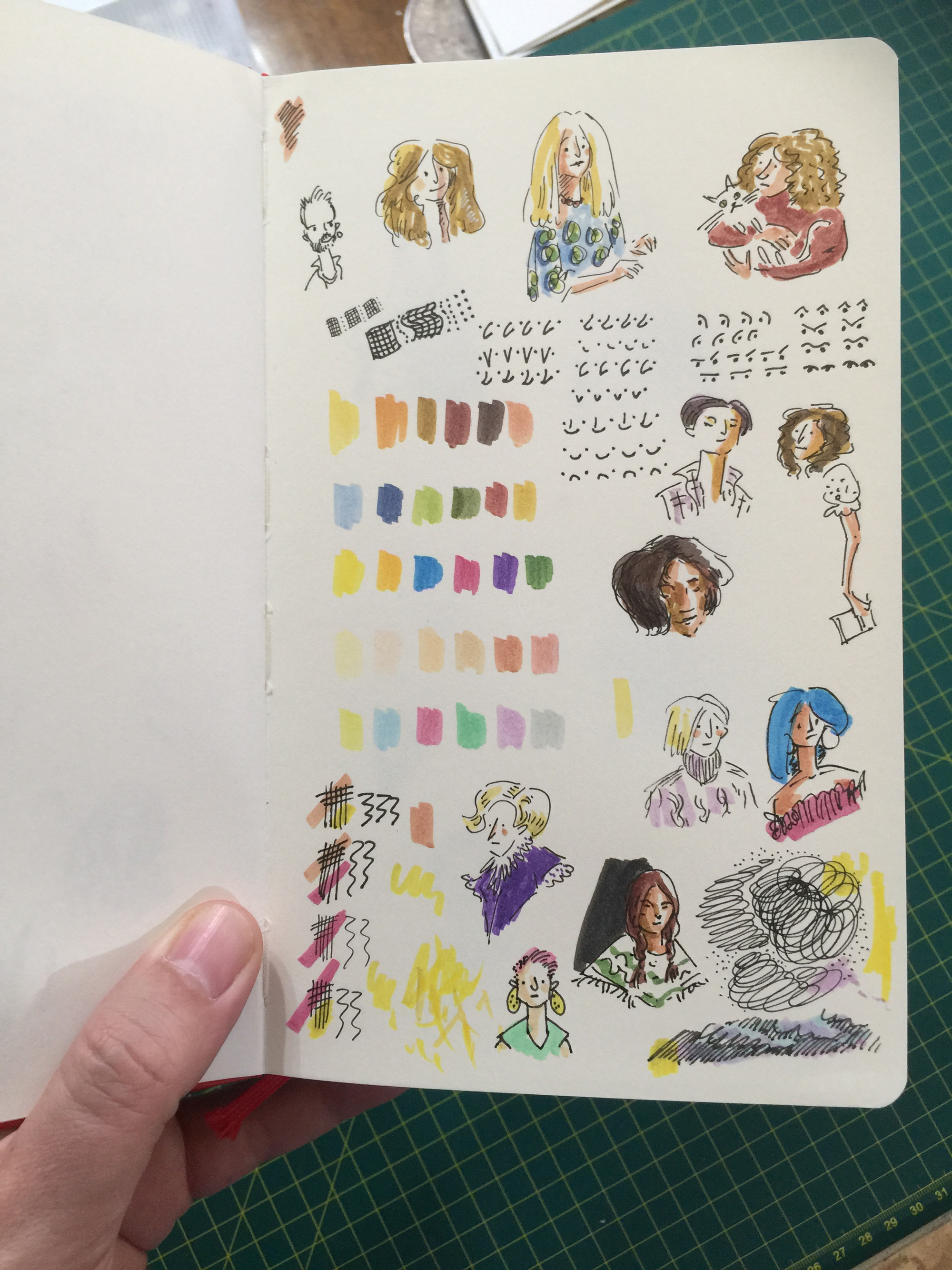 An open sketchbook filled with colour swatches and sketchy portraits