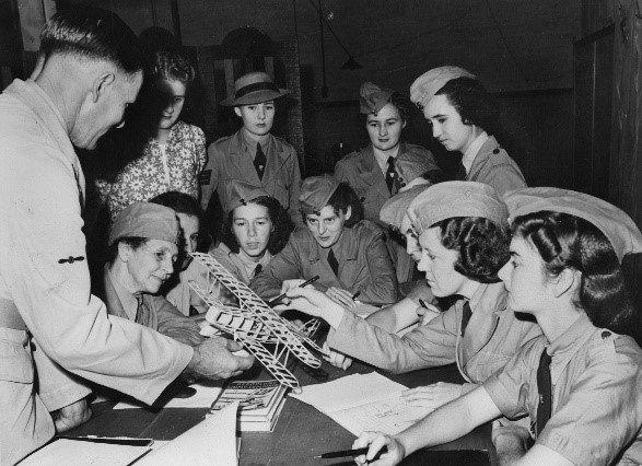 A group  of women looking at a model aeroplane