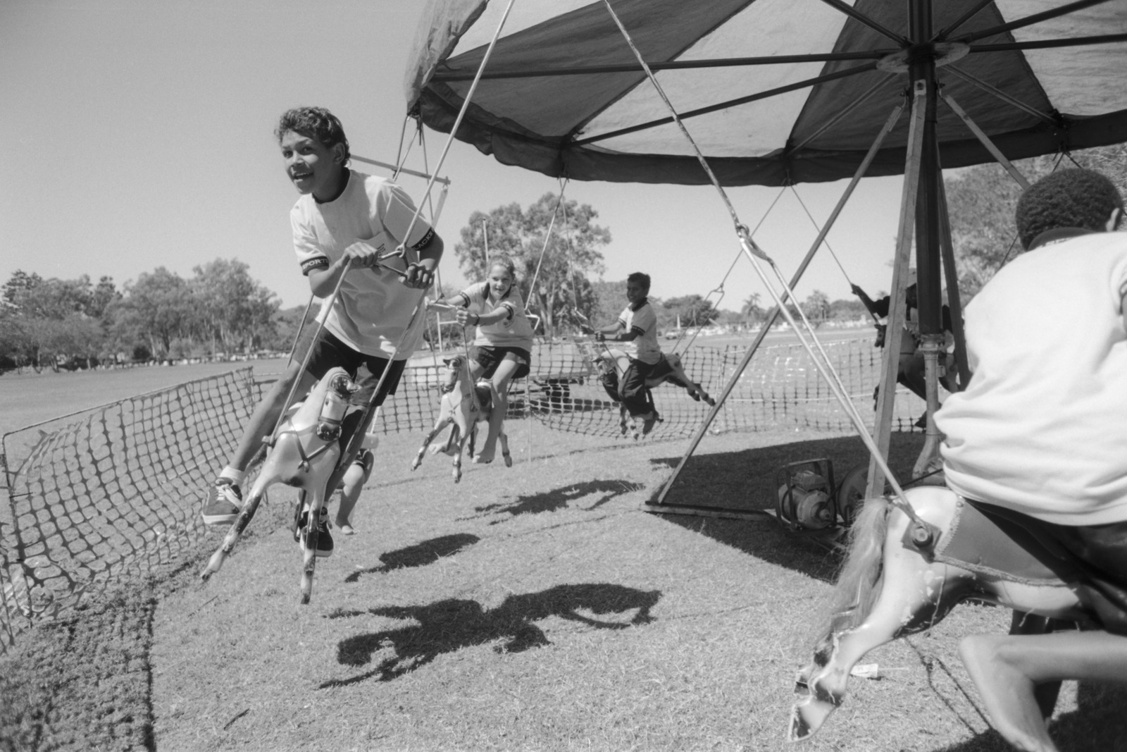 Children ride the merry-go-round on Recognition Day at Emmaus College, Rockhampton, 2000.