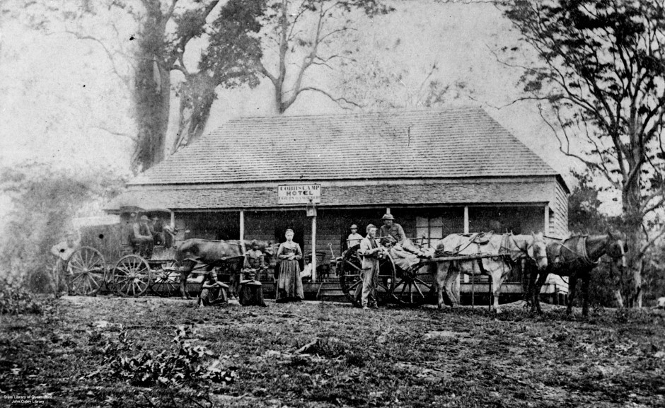 A picture of a homestead with horses and people out the front