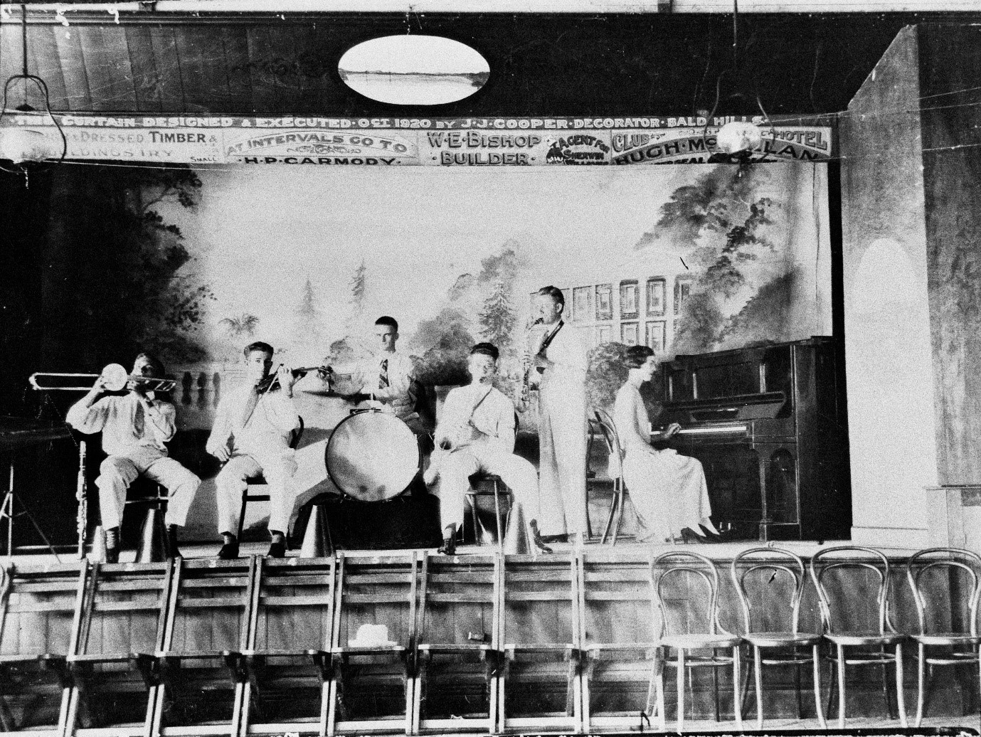Black and white image of six people playing instruments on a stage at Caboolture, ca. 1929.