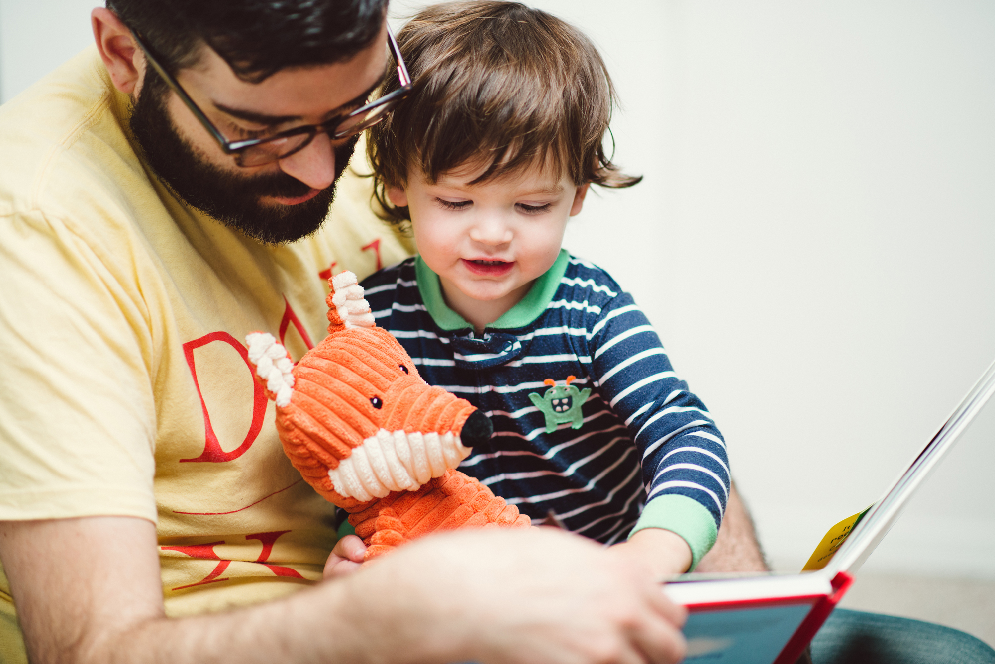 Dad with his toddler son reading a book