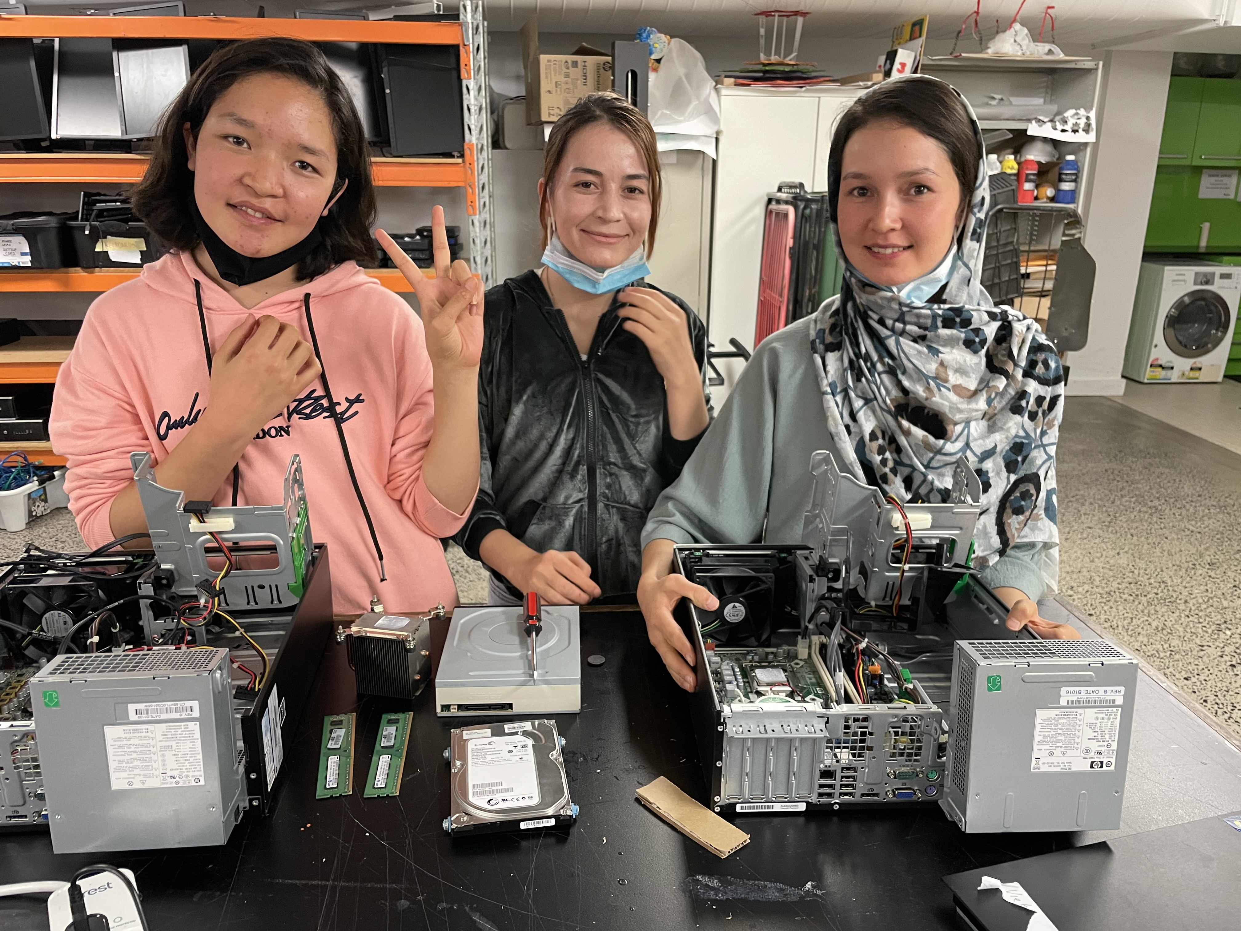 Image of 3 young women taking apart computers 