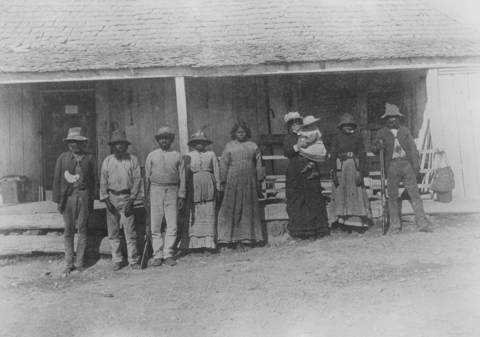 Black and white image of King Billy and group of Aboriginal people standing in front of a wooden building at Pikedale