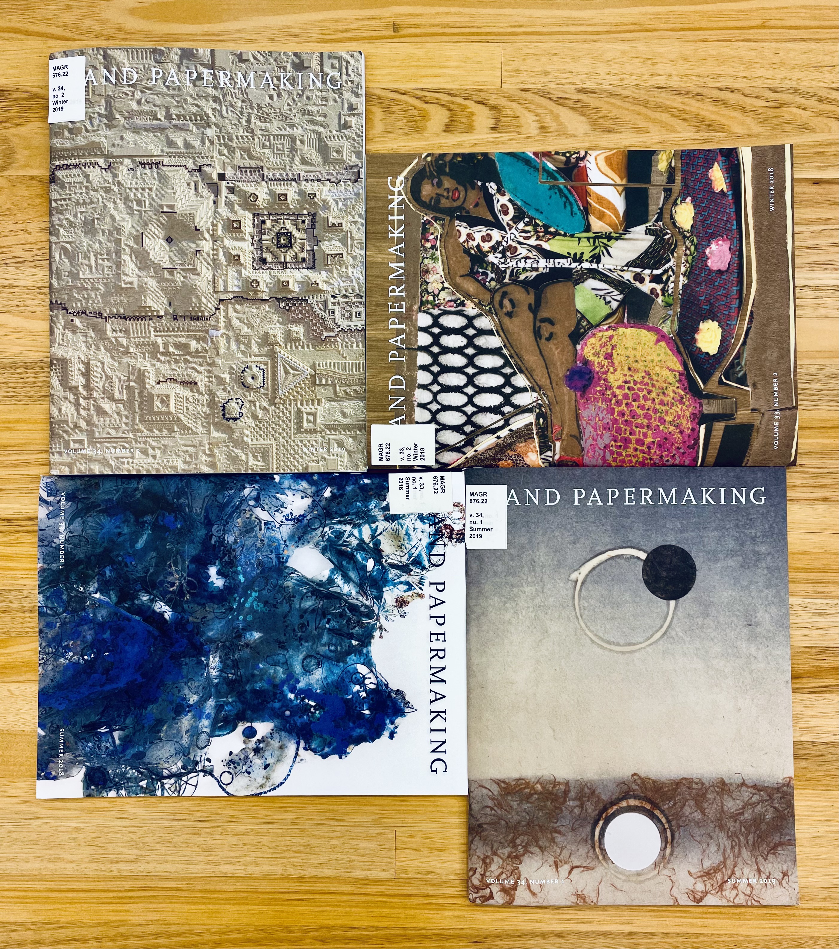 Image of four front covers for the magazine "Hand Papermaking" displaying different types of paper