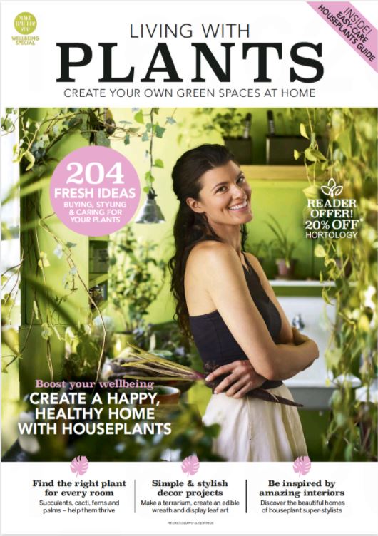 Image of front cover of "Living with Plants" magazine from Press Reader with woman standing side on surrounded by plants