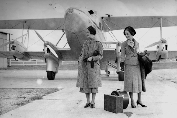 Fashion models in front of a plane taking part in an autumn feature of a McWhirter's Clothing supplement.