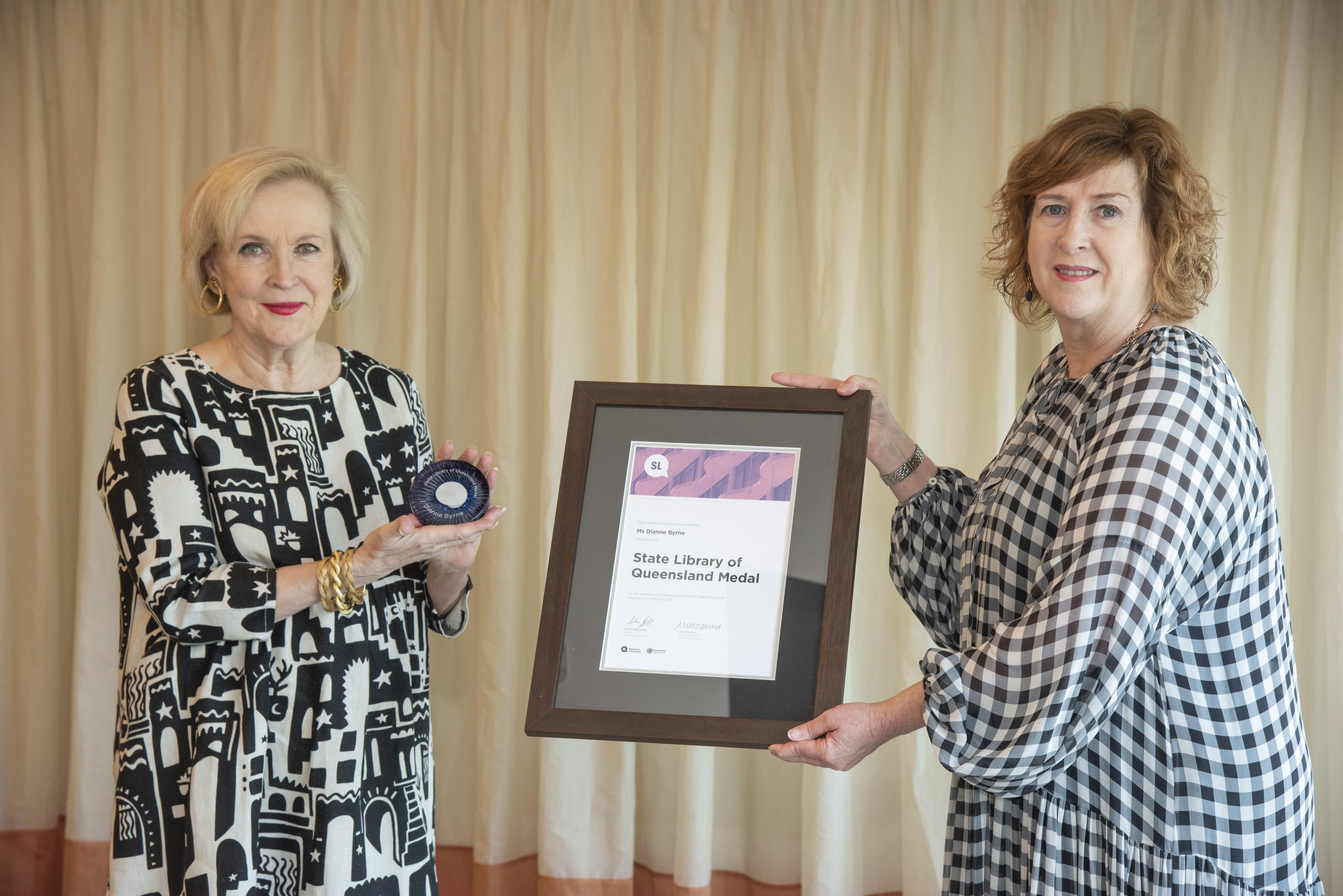 State Librarian, Vicki McDonald presenting Dianne Byrne with the State Library of Queensland Medal