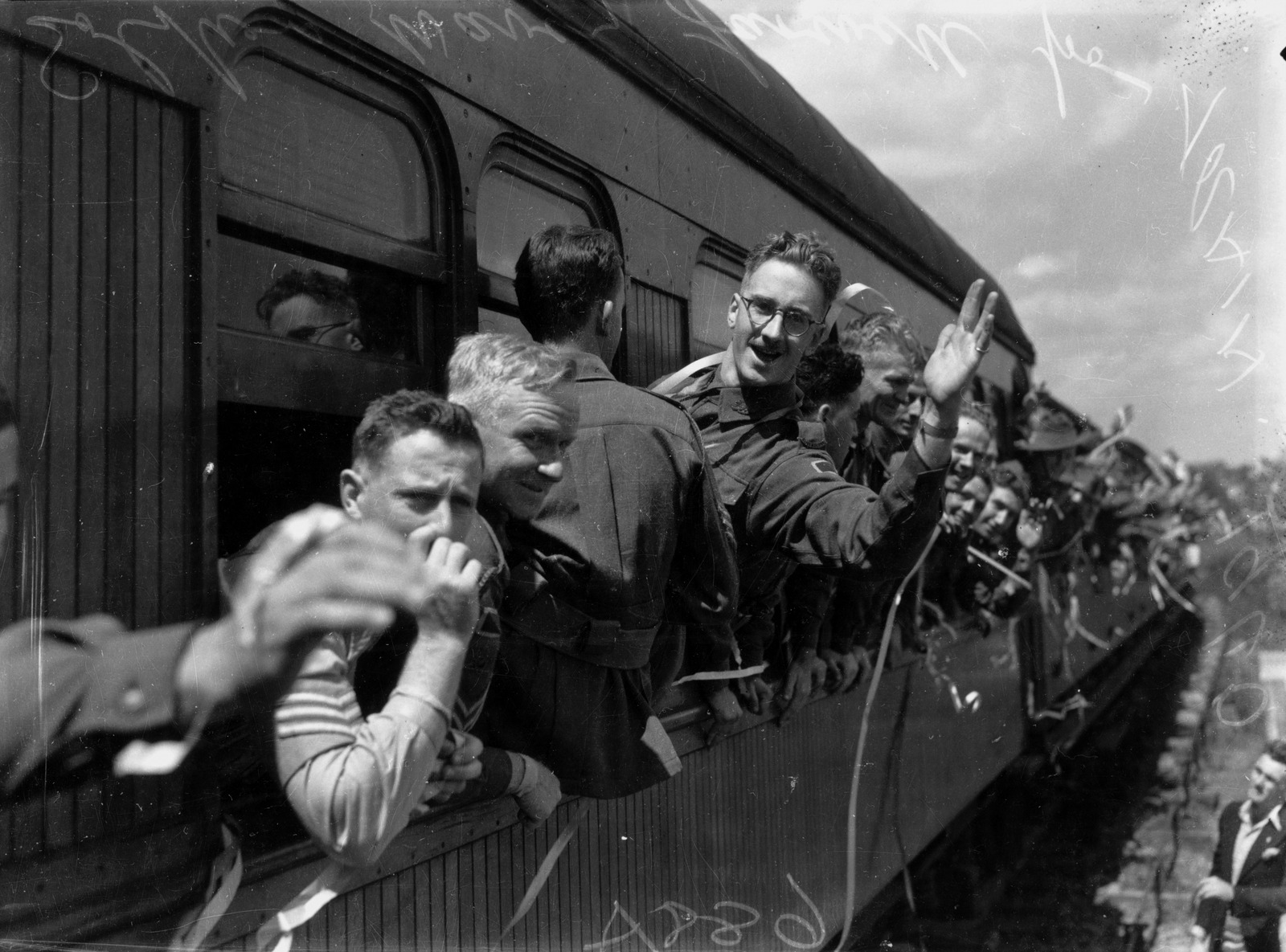 Soldiers lined up waiting to board the train and saying goodbye 