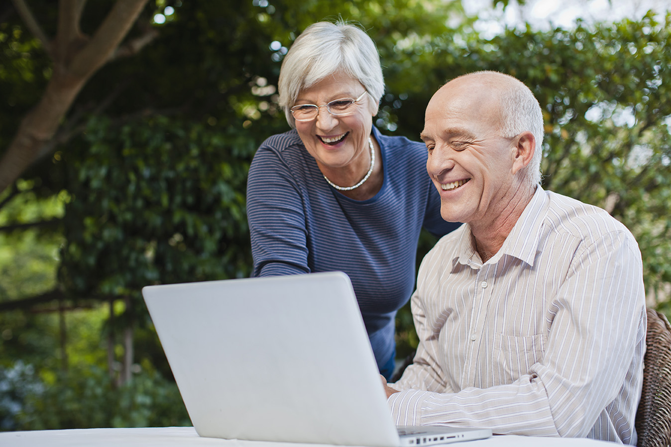 An older people sitting in front of a laptop