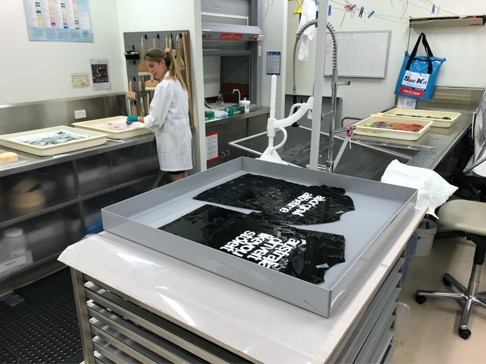 Textiles Conservator Louise McCullagh washing collection items in the Preservation Services lab at State Library of Queensland.