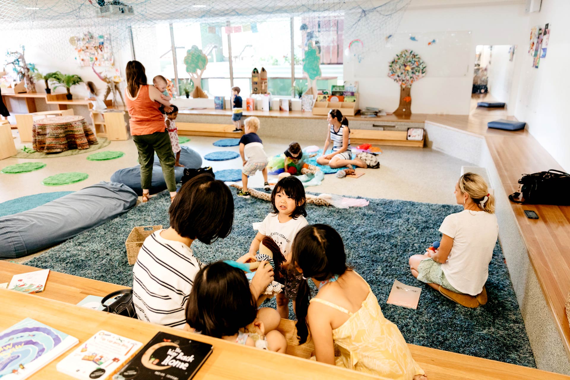 Children and adults playing together with toys and books in the Corner.