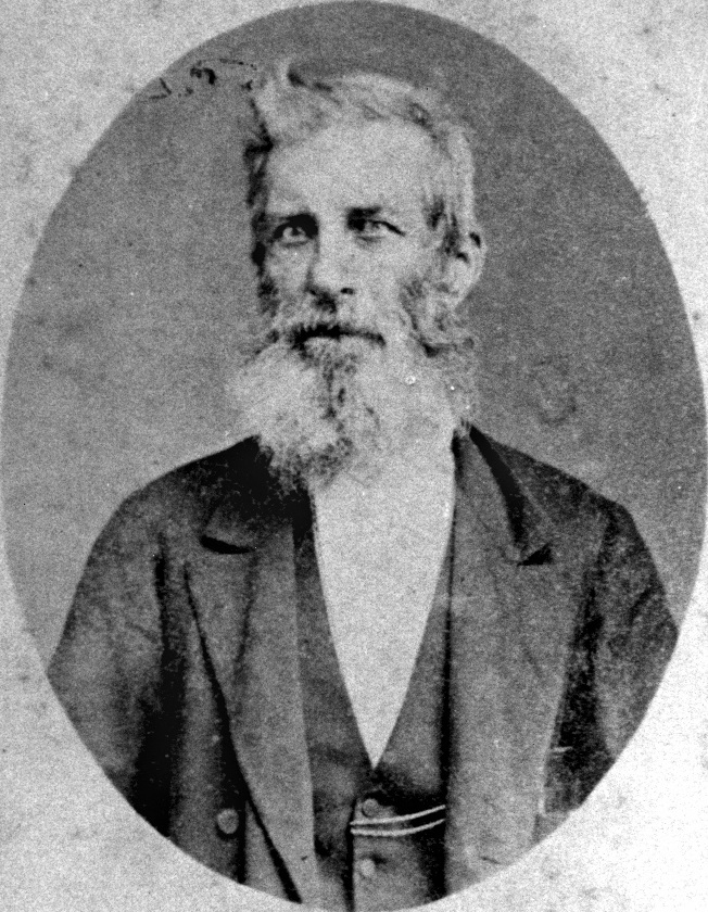 Portrait of Thomas Dowse, a caucasian man with a large whispy beard and cropped hair with a cowlick at the front. He is wearing an 1800's suit.