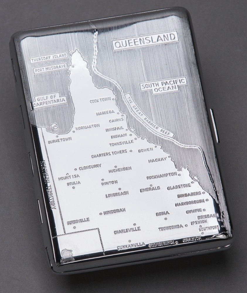 A polished silver cigarette case engraved with a map of Queensland.