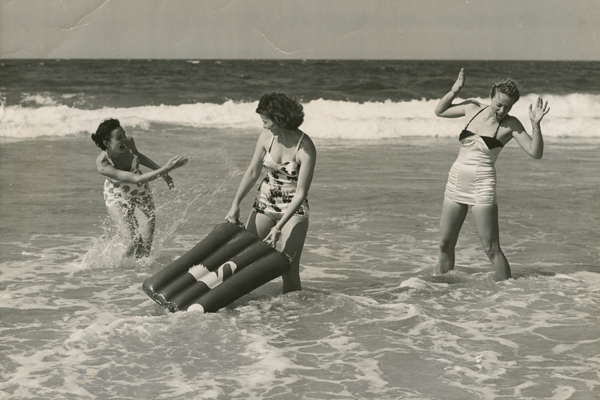 Young women playing in the surf, splashing each other