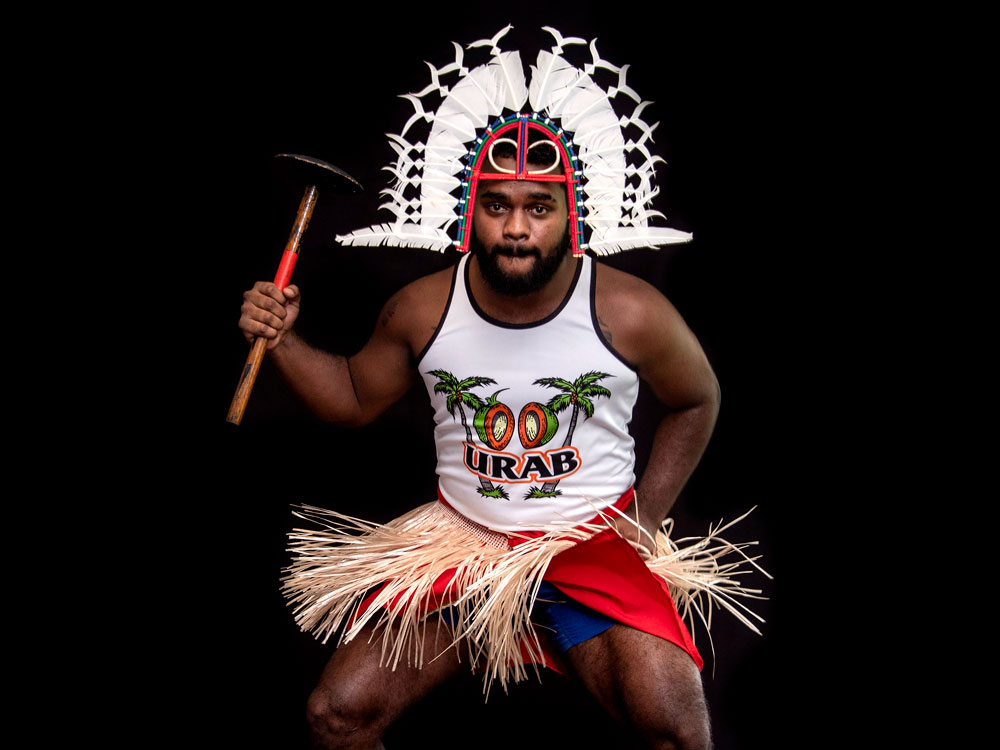 Man in traditional Indigenous headdress and Urab shirt