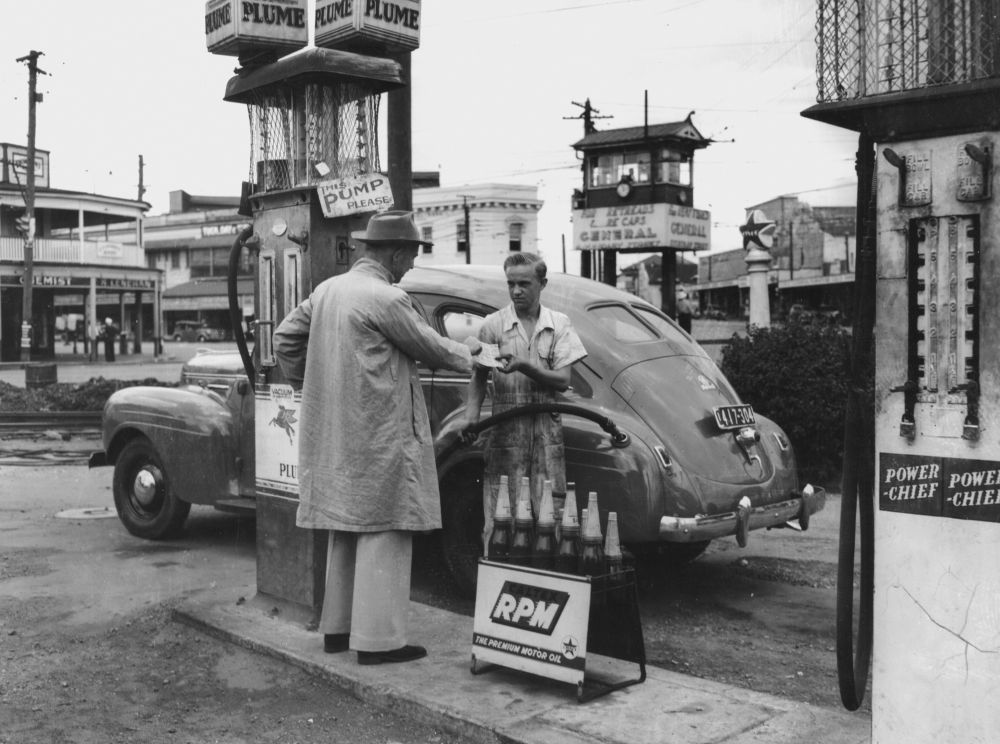 Filling the car with petrol at the Fiveways, Woolloongabba,1949  Photographer unknown  John Oxley Library, SLQ  Negative no. 161197