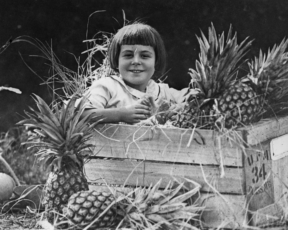 Girl sitting in a crate of Queensland pineapples, 1924