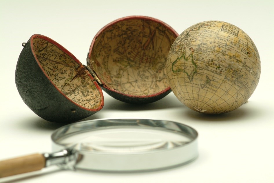 small globe next to its case and a magnifiying glass 