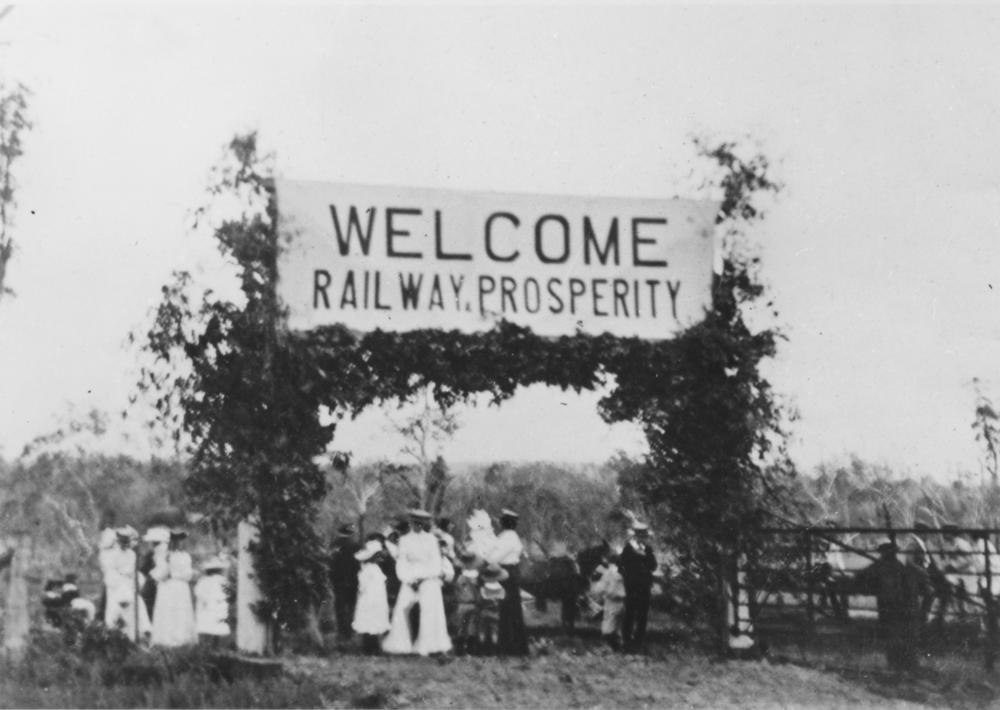 Group of people standing under a welcome sign at Kingaroy railway station 1904. 