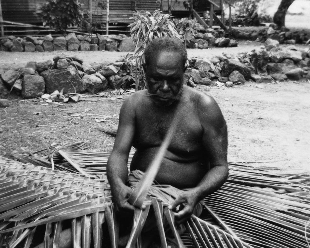 Murray Island man plaiting coconut leaves, 1958