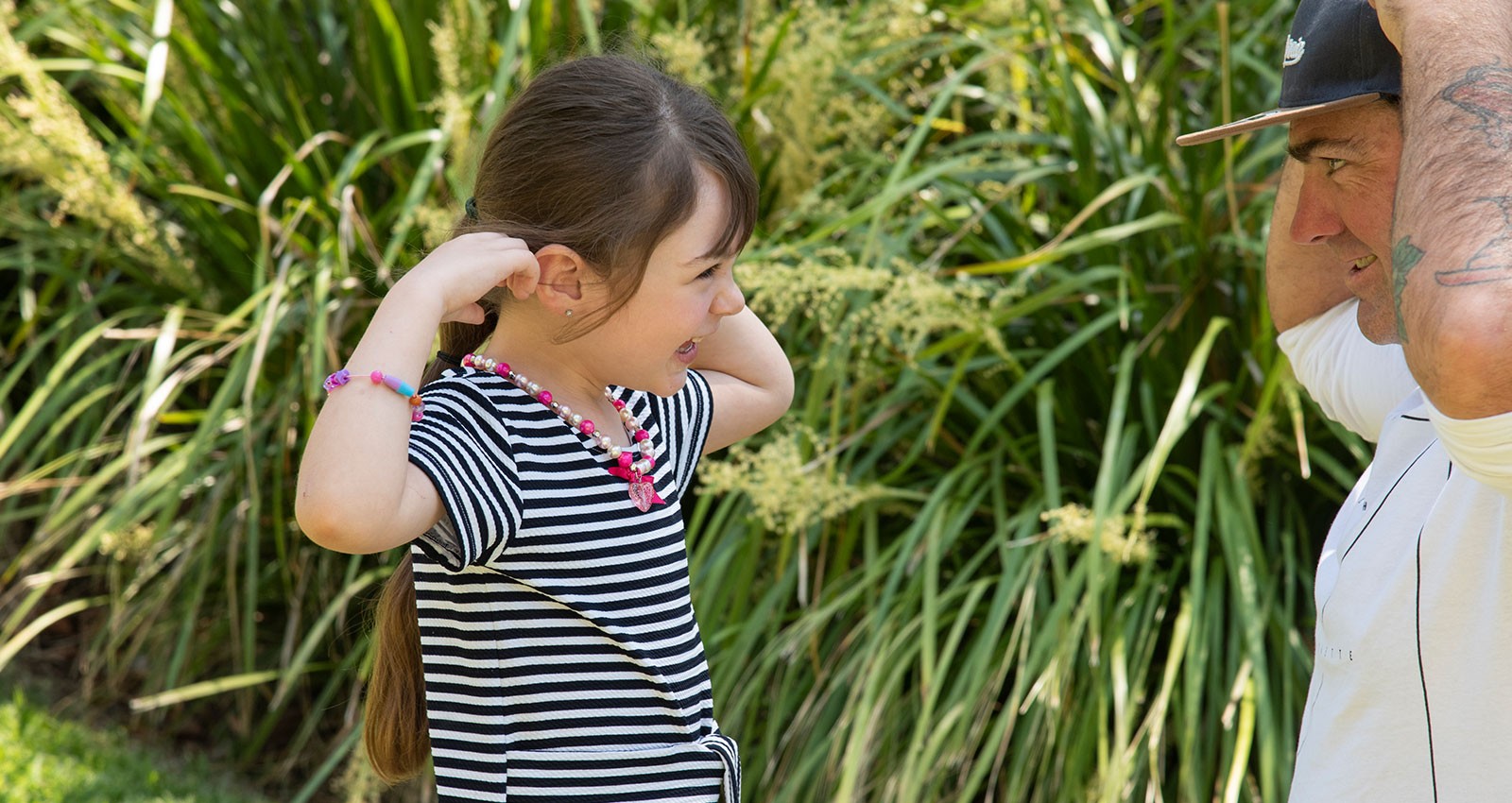 Child and man touching their own ears