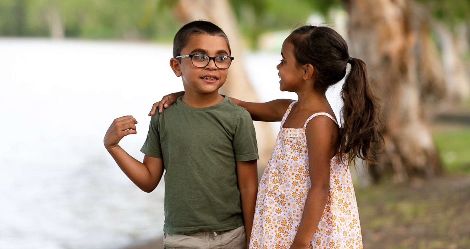 Boy and girls standing together by water