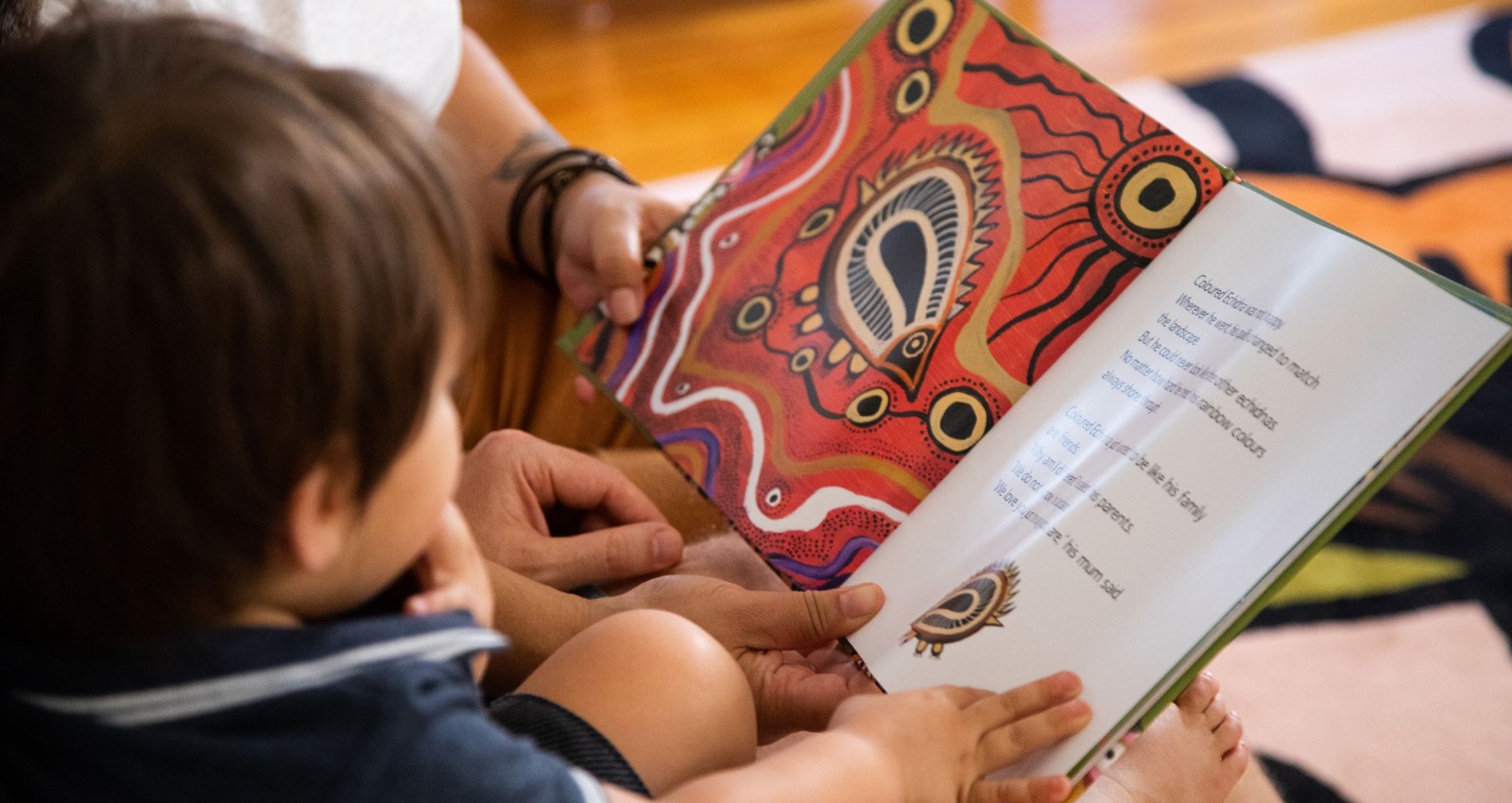 Family reading a book called The Coloured Echidna