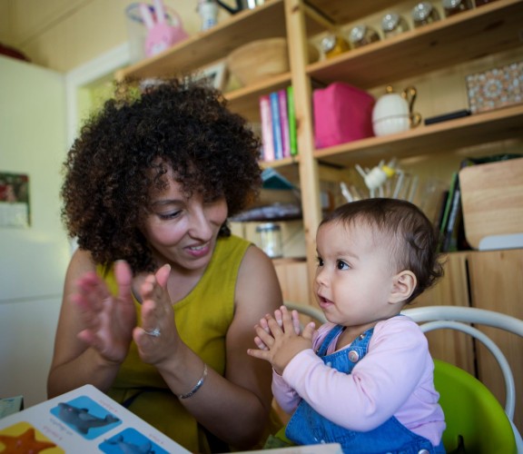 Woman and child using sign language to read a book
