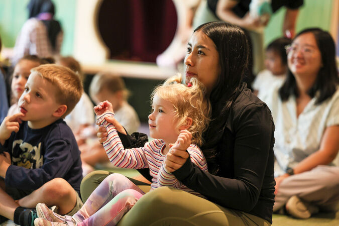 Parents and children sitting on the floor together.