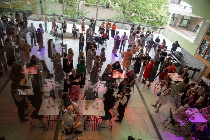 crowd of people on terrace refleced in glass ceiling