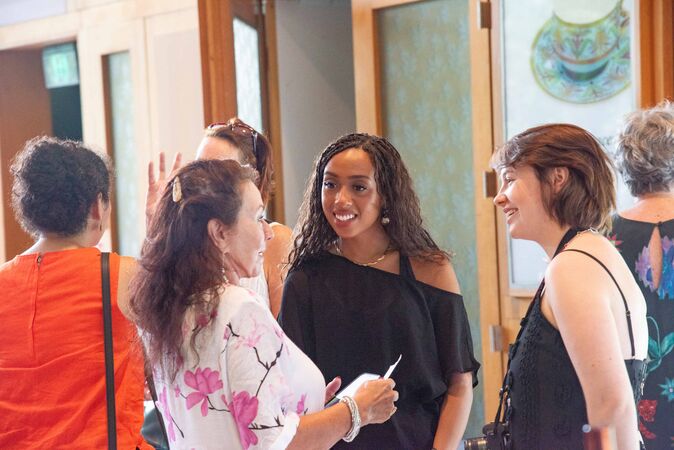 three women in conversation at social event