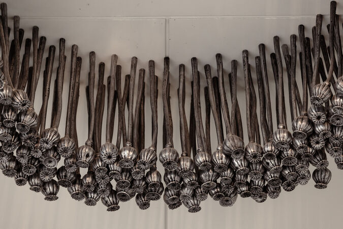 Detail from "Black Opium" by Fiona Foley showing aluminium poppies in an arrangement