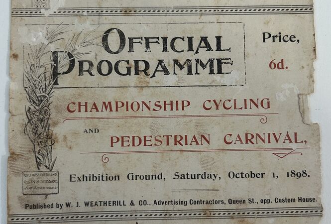Aged printed programme titled “Official Programme” for a Championship Cycling and Pedestrian Carnival, held at the Exhibition Ground on Saturday, October 1, 1898. Decorative typography in black and red, with ornate borders, shows wear, stains, and torn edges, and lists price as sixpence.