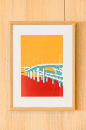 "Hot Modernism" poster framed on a wall showing an expressway in yellow, red and teal 