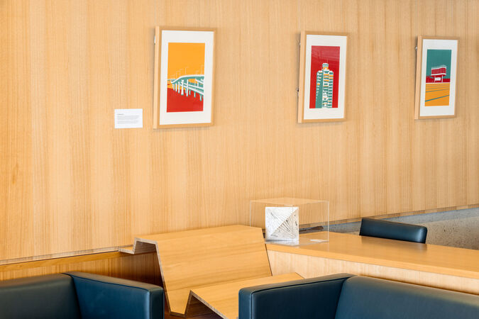 Three bright, framed illustrations line a timber wall