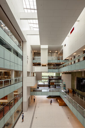 View of a a bright atrium inside a library showing balconies and people moving through the space