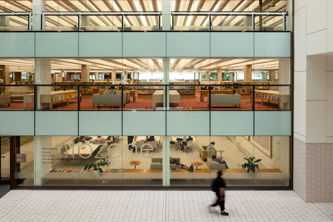 Side view of three levels of a library with people working inside