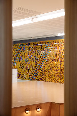 View from behind two poles showing a large installation artwork called "Kurilpa Country" by Lilla Watson 