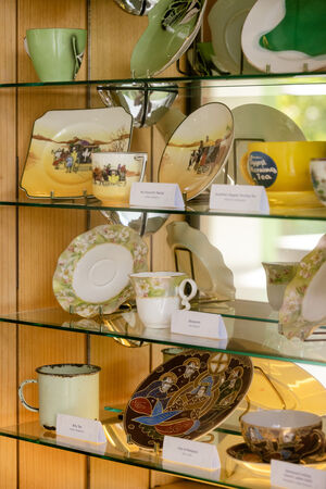 Tea sets on glass shelves in a cabinet