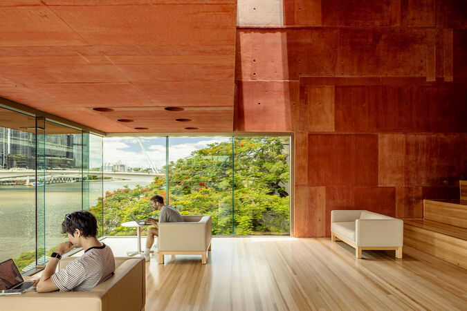 Red Box at State Library of Queensland; two people are working on laptops on couches