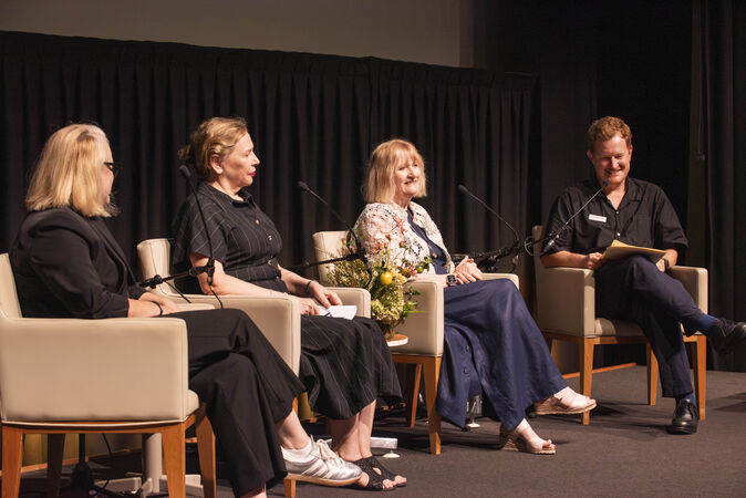 Three panelists and one host on stage at Research Reveals