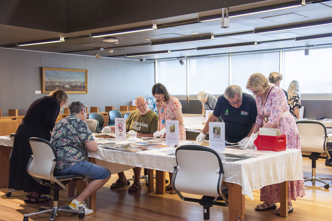 Attendees browsing historical collections on a table