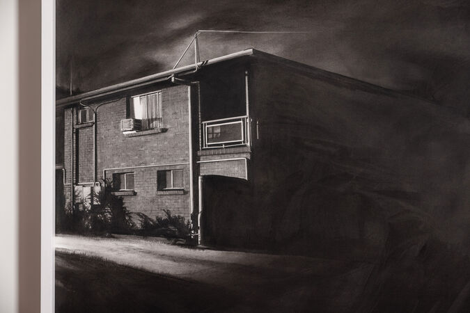 A large black and white drawing of a block of flats at night