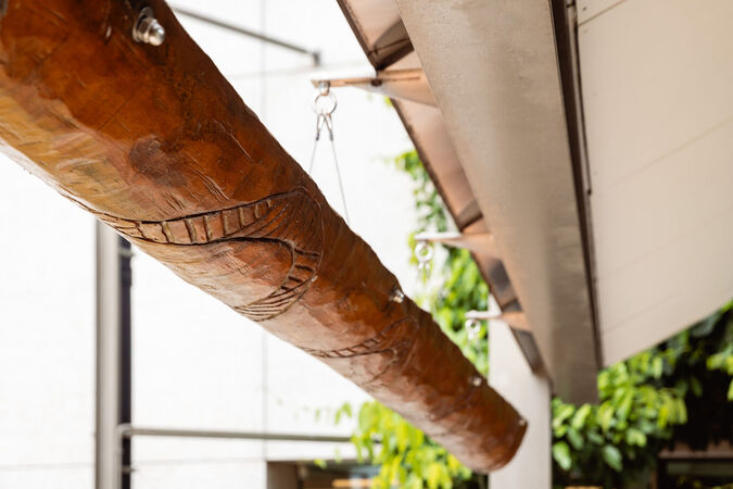 Close up of a large wooden coolamon by Laurie Nilsen hanging in the Talking Circle