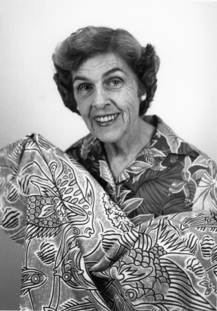 Textile designer and commercial artist Olive Ashworth holding a piece of material 