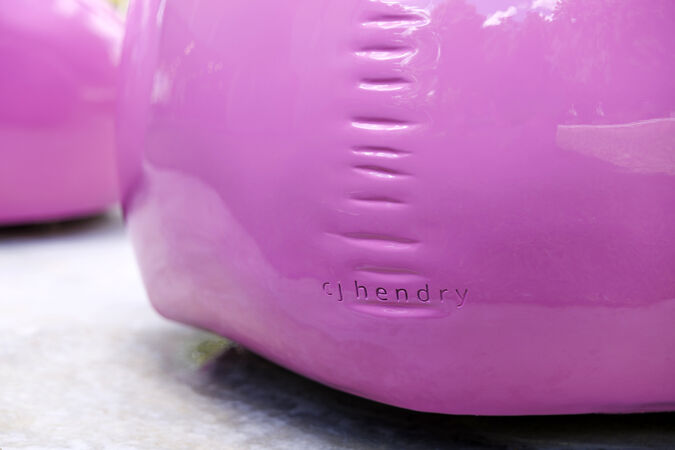 A close up of a bright pink artwork with the words Cj Hendry stamped on the side