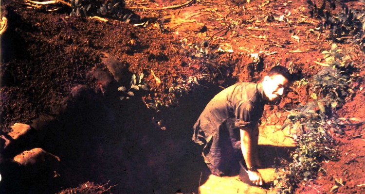 Joe bails water out of  weapons cache. Arriving in the wet season meant that the Vietnamese water table was only centimetres below the surface of the ground